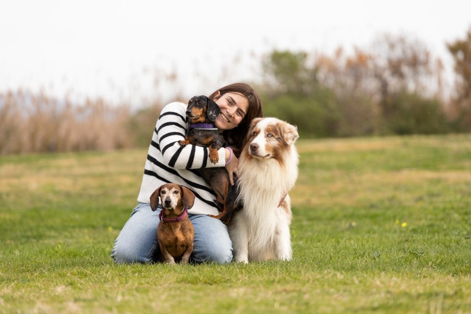 Ritratto di famiglia felice con cani al parco per un servizio fotografico per cani a Cagliari